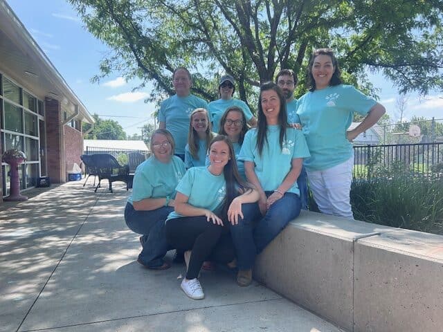 Volunteers smiling outdoors at northernplainspl.org community event, sunny day, group photo, team teamwork and engagement, nonprofit organization active participation in North Dakota.