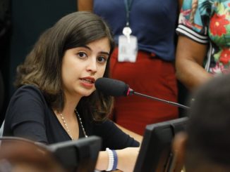 Tecnóloga ambiental falando em reunião sobre sustentabilidade e conservação do meio ambiente.