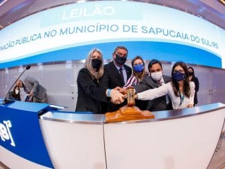 Leilão de iluminação pública realizado na prefeitura de Sapucaia do Sul, evento oficial com autoridades usando máscara, destacando o compromisso com sustentabilidade e gestão pública eficiente.