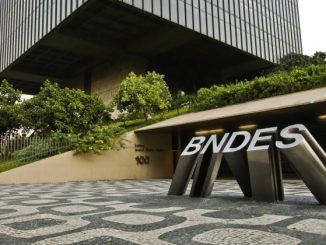 BNDES logo em frente ao prédio corporativo, representando financiamento de projetos sustentáveis e investimentos estratégicos no Brasil.