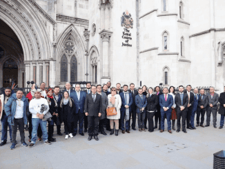 Pessoas reunidas em frente ao tribunal de justiça, grupo de profissionais em evento jurídico, arquitetura histórica do prédio ao fundo, símbolo da justiça e direito brasileiro, imagem relacionada a eventos jurídicos e empresariais.