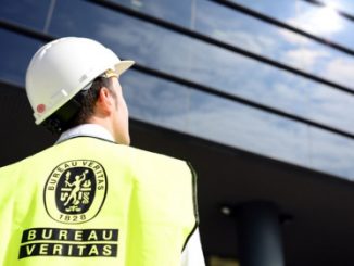 Inspector de segurança com capacete branco observando painel solar fotovoltaico ao ar livre, representando controle ambiental, sustentabilidade e energias renováveis no setor ambiental.