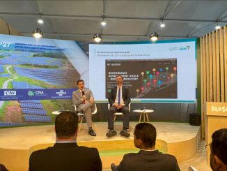 Infraestrutura de evento com painel de apresentação sobre sustentabilidade, painéis solares e inovação em energia renovável no Brasil, durante conferência ambiental.