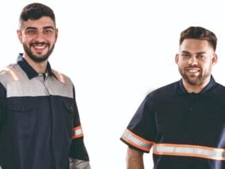 Homens usando uniformes de segurança com faixas refletivas, representando segurança no trabalho e prevenção de acidentes, ideal para imagens relacionadas a ambiental, segurança e normas de segurança no trabalho.