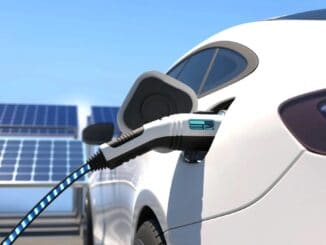 Carro elétrico conectado à estação de carregamento com painéis solares ao fundo, representando sustentabilidade e energia limpa.