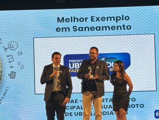 Prêmio de reconhecimento em saneamento entregue a autoridades públicas, destacando exemplo de gestão ambiental e saneamento no município de Ubaitaba.