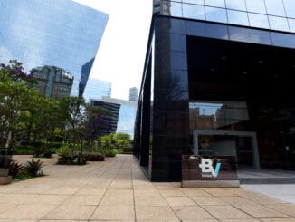 Banco BV em prédio corporativo com fachada de vidro e área externa com jardins e árvores. Ambiente empresarial moderno, destaque para sustentabilidade e infraestrutura financeira.