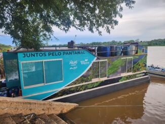 Barco de fiscalização ambiental no Rio Amazonas em Cuiabá, com mensagem promovendo a preservação e consciência ecológica na região amazônica.