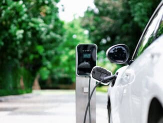 Carro elétrico sendo carregado em ponto de recarga em ambiente urbano, promovendo sustentabilidade e mobilidade limpa. Estação de energia para veículos elétricos, reforçando o compromisso com o meio ambiente e inovação tecnológica.