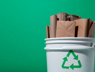 Pilhas de papel e papelão em balde de reciclagem, símbolo de sustentabilidade e gestão de resíduos ambientais. Foco em reciclagem, sustentabilidade e cuidado ambiental no Brasil.