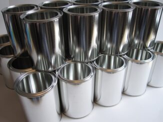 Latas de tinta prateadas empilhadas, acabamento metálico brilhante, indústria de embalagens, sustentabilidade ambiental, reciclagem de alumínio, produção de embalagens sustentáveis.
