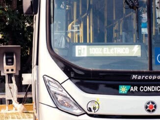 Veículo elétrico de transporte público conectado à estação de recarga, com foco em sustentabilidade, energia renovável e inovação no setor de transportes ambientais.