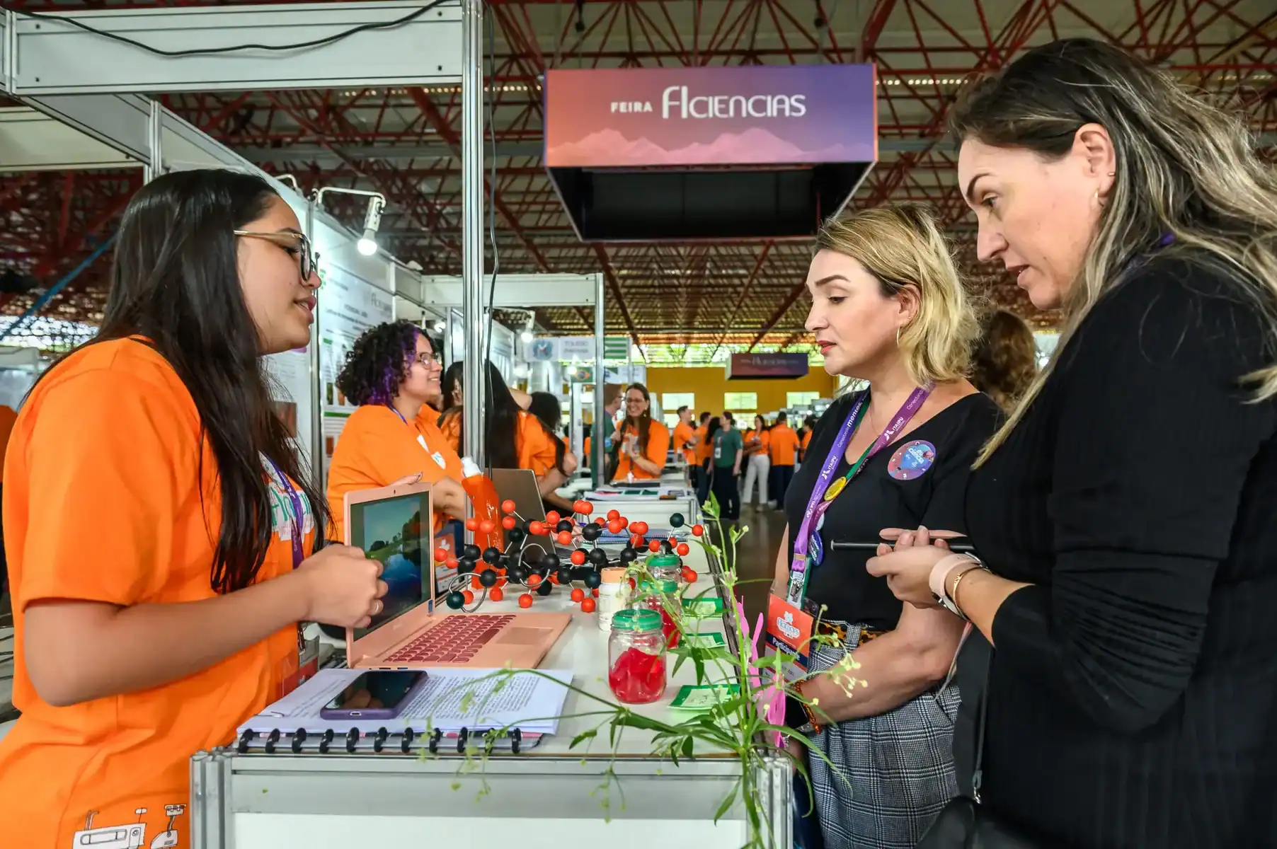 Feira de ciências ambiental mercantil com participantes em apresentação de projetos sustentáveis em ambiente de exposições ambientais.