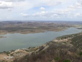 Largura de um rio ou reservatório em uma paisagem natural, vista de cima, com área de terra ao redor e céu com nuvens. Ambiente de patrimônio natural e recursos hídricos, relevância ambiental para conservação.