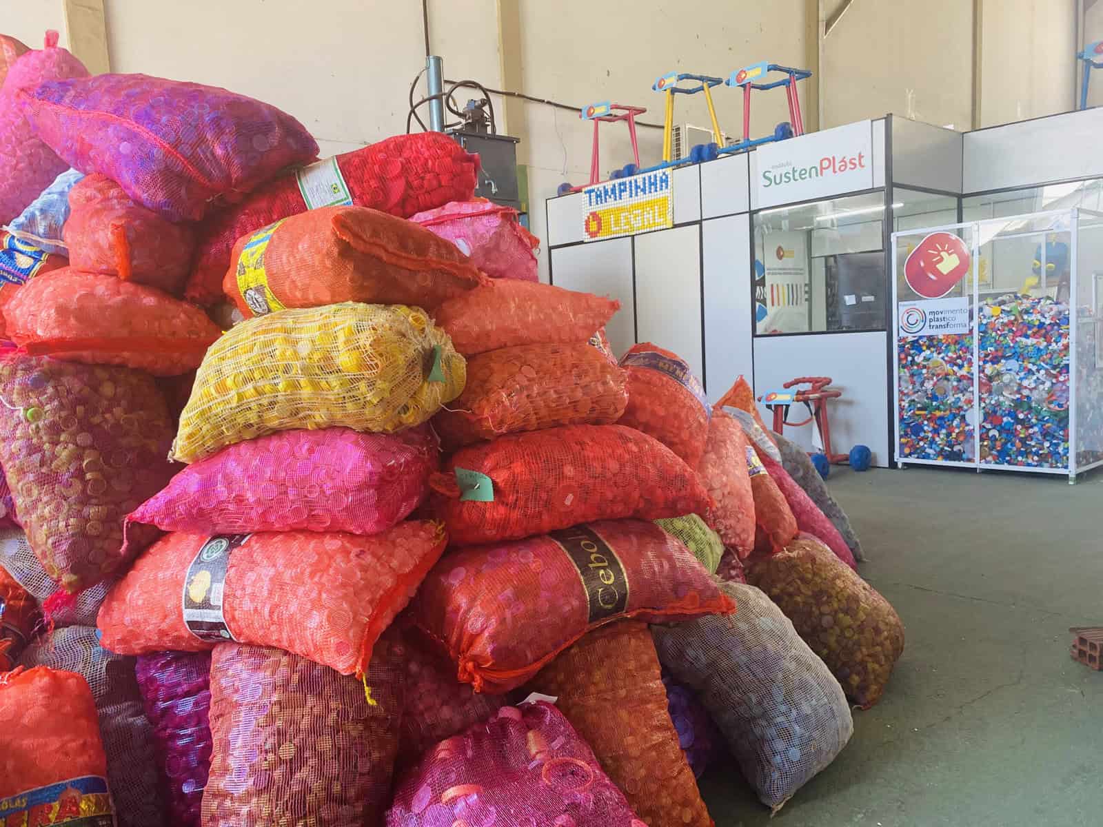 Sacos de materiais plásticos reciclados empilhados em centro de reciclagem de plástico, promovendo sustentabilidade e economia circular no setor ambiental.
