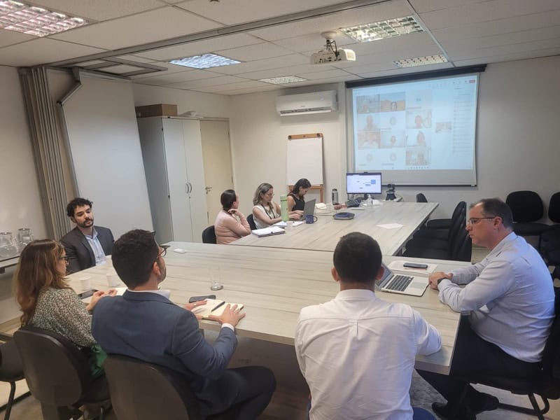 Reunião de equipe com apresentação virtual, foco em sustentabilidade e responsabilidade ambiental para negócios conscientes, promovendo troca de experiências e estratégia empresarial eficiente.