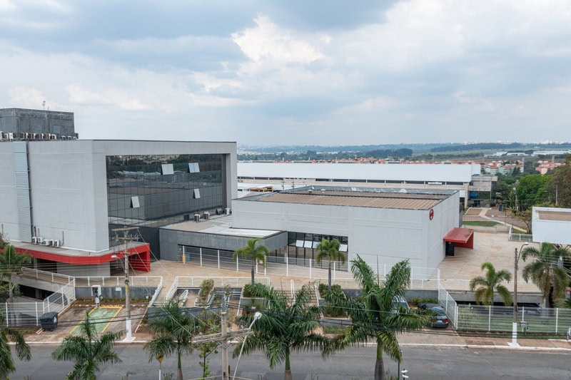Centro de distribuição logístico da Ambiental Mercantil com ampla infraestrutura, fachada moderna e área de armazenamento, promovendo sustentabilidade e eficiência no transporte de produtos ambientais.