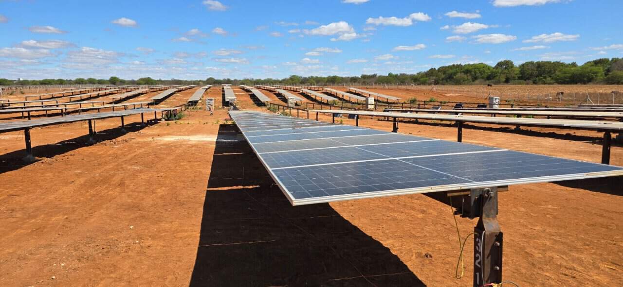Transformador solar em parque de geração de energia renovável, com painéis solares instalados em sólo arenoso, evidenciando energia limpa e sustentável, caminhando para futuro energético mais verde.