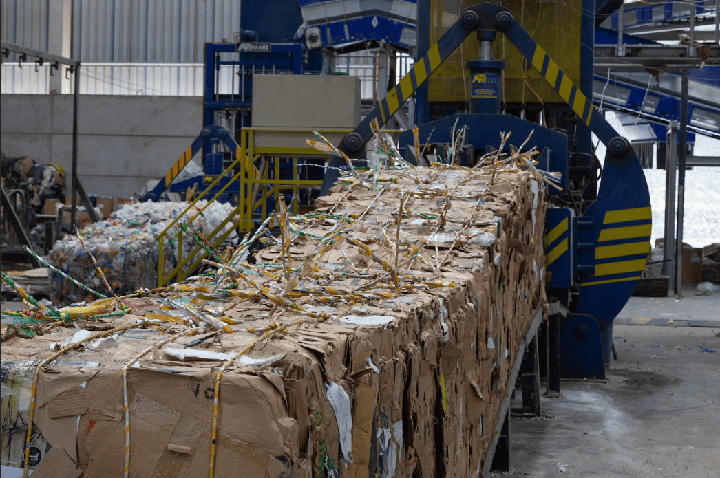 Caixa de papelão sendo processada em máquina de reciclagem industrial, promovendo sustentabilidade e gerenciamento de resíduos ambientais. A tecnologia de reciclagem contribui para a economia circular no setor de resíduos sólidos.