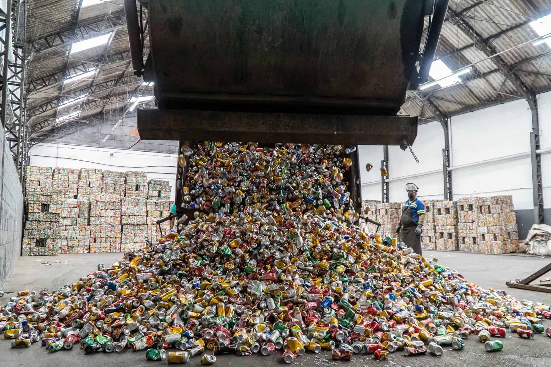 Pilhas de latas de alumínio sendo recicladas em uma usina de processamento ambiental. Processo de reciclagem de resíduos metálicos para promover sustentabilidade e economia circular.