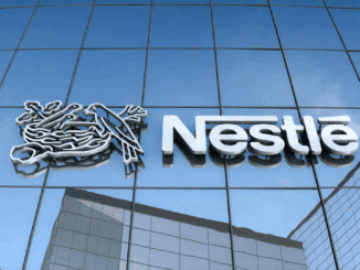 Banco de imagens, fachada de escritório com logo da Nestlé em fachada de vidro refletindo edifícios ao redor, representação de sustentabilidade e responsabilidade social empresarial.