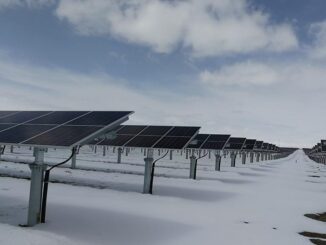 Painéis solares em campo sob céu parcialmente nublado, ilustrando energia renovável e sustentabilidade ambiental.