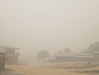 Poluição do ar com fumaça densa cobrindo uma comunidade rural, destacando os desafios ambientais e a importância de ações sustentáveis para a preservação do meio ambiente.