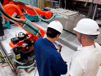 Robôs industriais e operadores em fábrica de automação, destaque para tecnologia de ponta em manufatura.