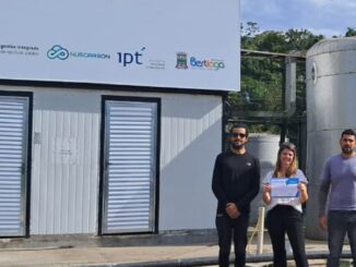 Tanque de armazenamento de resíduos ambientais com equipe técnica ao fundo, enfatizando compromisso com sustentabilidade e gestão de resíduos industriais no Brasil.