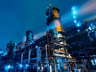 Refinaria industrial com iluminação azul, destacando tecnologia e produção de petróleo, no ambiente de energia e recursos naturais.