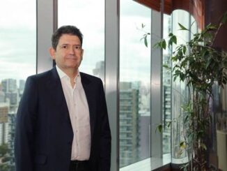 Executivo de negócios em ambiente corporativo com vista urbana ao fundo, destacando profissionalismo e liderança no setor ambiental e mercantil.