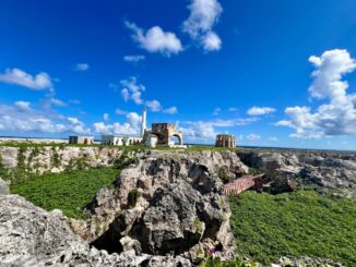 Antiga estrutura de mineração em ambiente natural com rochas e vegetação sob céu azul, destacando a importância da preservação ambiental e sustentabilidade na indústria mineral.