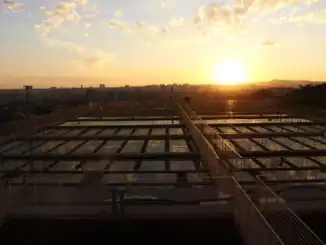 Painéis de gestão de resíduos ambientais ao pôr do sol, destacando projetos sustentáveis e controle ambiental.