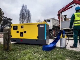 Gerador de energia portátil sendo operado por técnico com equipamento de proteção em teste ao ar livre, importante para emergência e sustentabilidade ambiental.