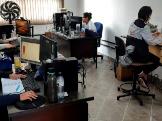 Pessoas trabalhando em escritórios com computadores e equipamentos de escritório, ambiente de trabalho organizado.