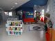 Biblioteca infantil com estantes cheios de livros coloridos e espaço aconchegante para leitura. Ambiente moderno e bem iluminado, ideal para estimular o hábito da leitura entre crianças.
