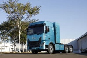 Caminhão azul de transporte de cargas em estrada movimentada no Brasil.