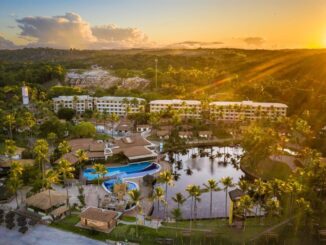 Piscina e resort tropical ao pôr do sol, com muita vegetação e área de lazer. Destino ideal para férias ecológicas, com piscinas, natureza e tranquilidade.