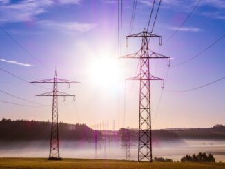 Linhas de transmissão de energia elétrica ao nascer do sol, representando infraestrutura de energia sustentável e geração de eletricidade.