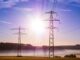 Linhas de transmissão de energia elétrica ao nascer do sol, representando infraestrutura de energia sustentável e geração de eletricidade.