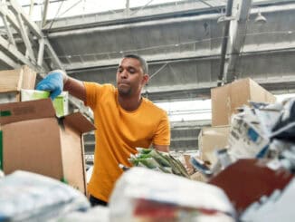 Recolhendo papelão e materiais recicláveis em ambiente industrial para promover a sustentabilidade e o gerenciamento de resíduos.