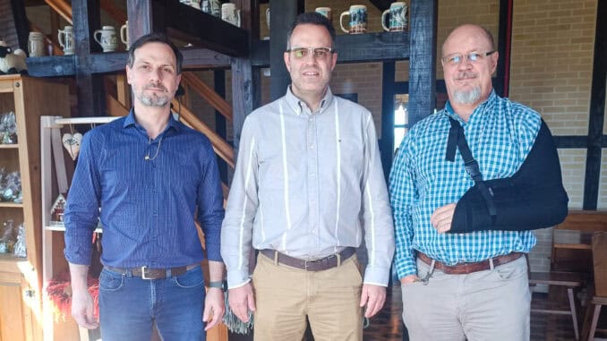 Homens em reunião empresarial, discutindo sustentabilidade e meio ambiente em ambiente de escritório moderno.