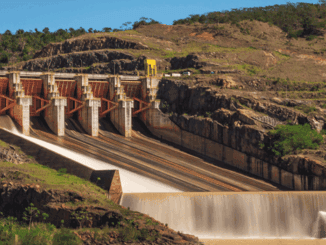 Alternativa de texto: Usina hidroelétrica com grande barragem e fluxo de água, gerando energia renovável e sustentável para a matriz energética brasileira.