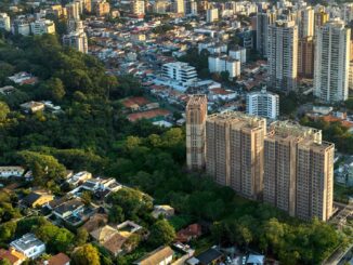Edifícios residenciais cercados por áreas verdes na cidade de Curitiba, Paraná, perfil urbano sustentável e integração com meio ambiente.