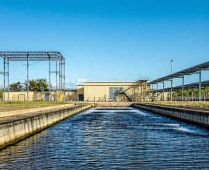 Tanque de água industrial em instalação de tratamento ambiental, com infraestrutura moderna, destacando o compromisso com sustentabilidade e gestão de recursos hídricos.
