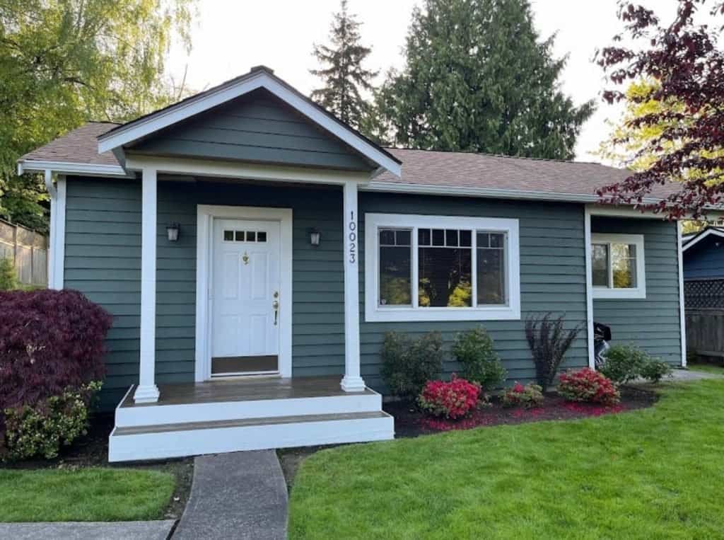Beautiful blue house with white trim and a well-maintained lawn.