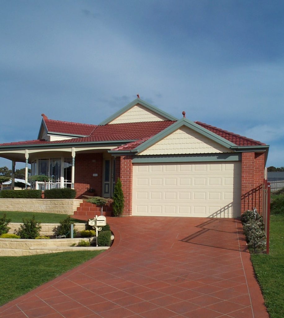 Stenciled concrete driveway in Officer with red and cream decorative border