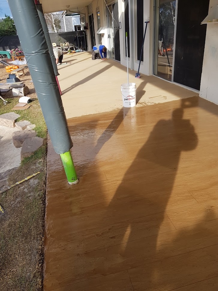 Half-sealed concrete showing fresh sealer application