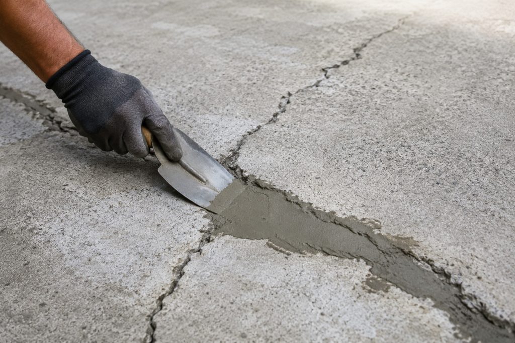 Concrete crack repair being carried out on damaged concrete surface