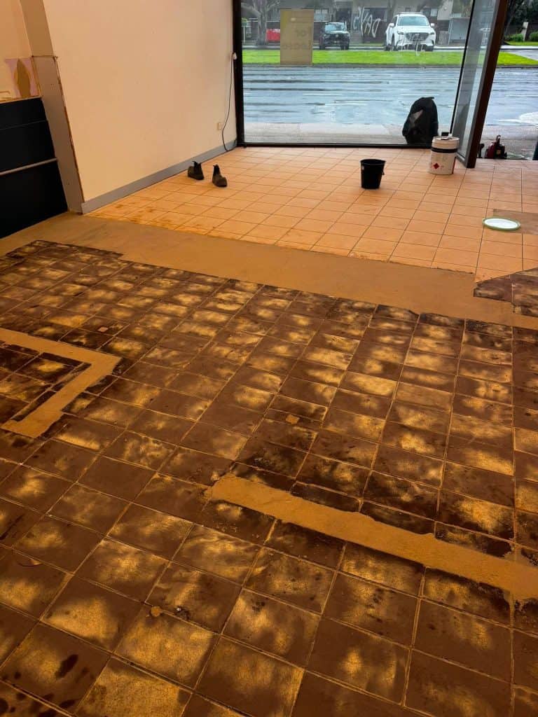Commercial shop floor with tiles removed before epoxy flooring installation in Rosebud